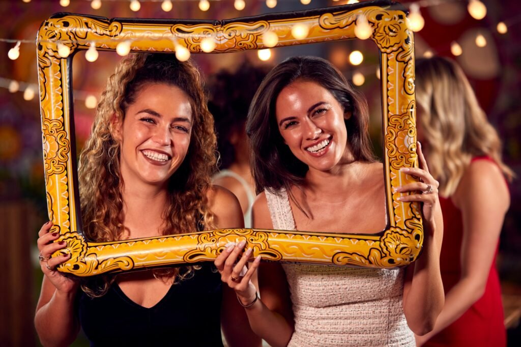 Female Friends Having Fun Posing With Photo Booth Photo Frame At Party In Dubai, UAE | Upshot SFX